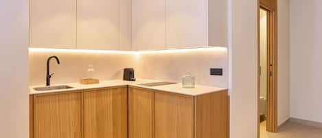 A modern kitchen with wooden cabinets, a sink, and a countertop.
