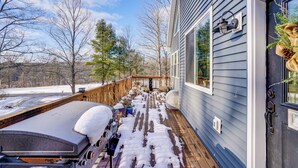 A deck with snow-covered railings, a grill, and a wooden deck extending from a house with a gray siding exterior. - WFH Friendly! Quiet Greenville Home w/ Deck (Greenville)