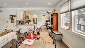 A dining area with a wooden table, chairs, and a vase of flowers. - WFH Friendly! Quiet Greenville Home w/ Deck (Greenville)