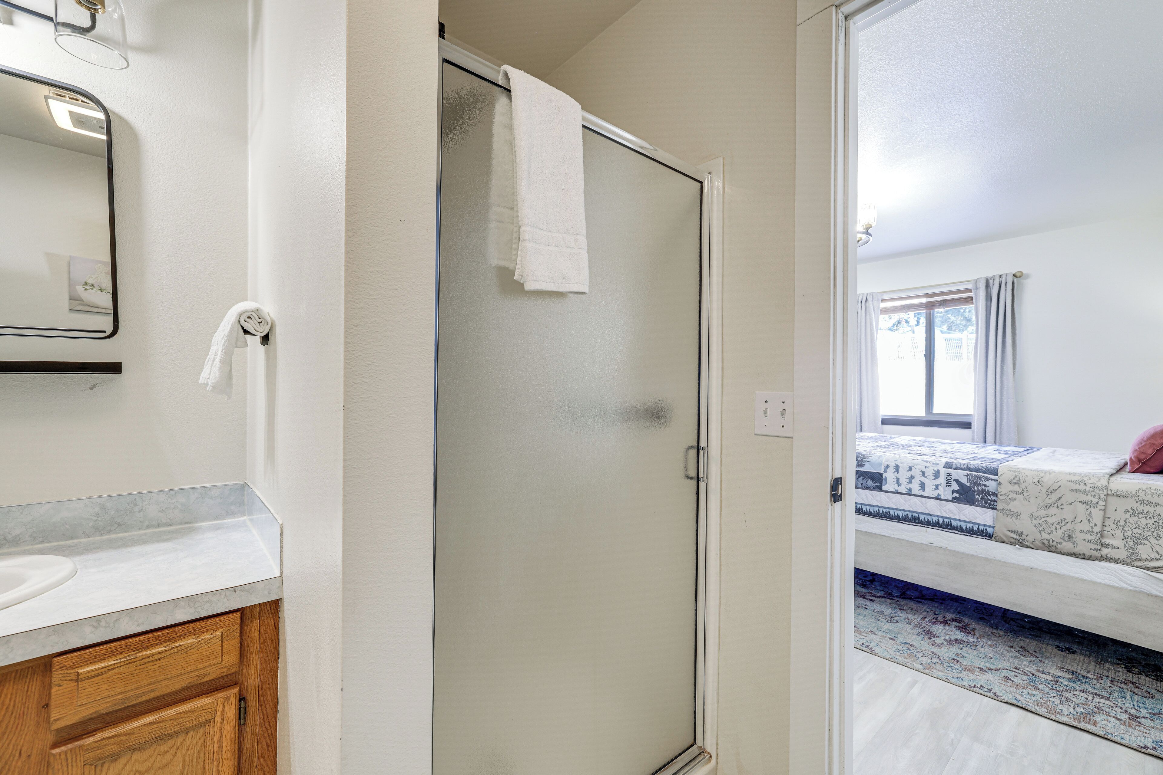 A bathroom with a shower, a sink, and a mirror.
