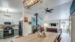 A spacious kitchen with modern appliances, a dining area with a wooden table, and a cozy seating area with a fireplace. - Family Home w/ Game Room, 1 Mi to Lake Cascade! (Cascade)