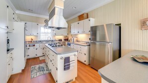 Una cocina moderna con armarios blancos, electrodomésticos de acero inoxidable y una isla central.