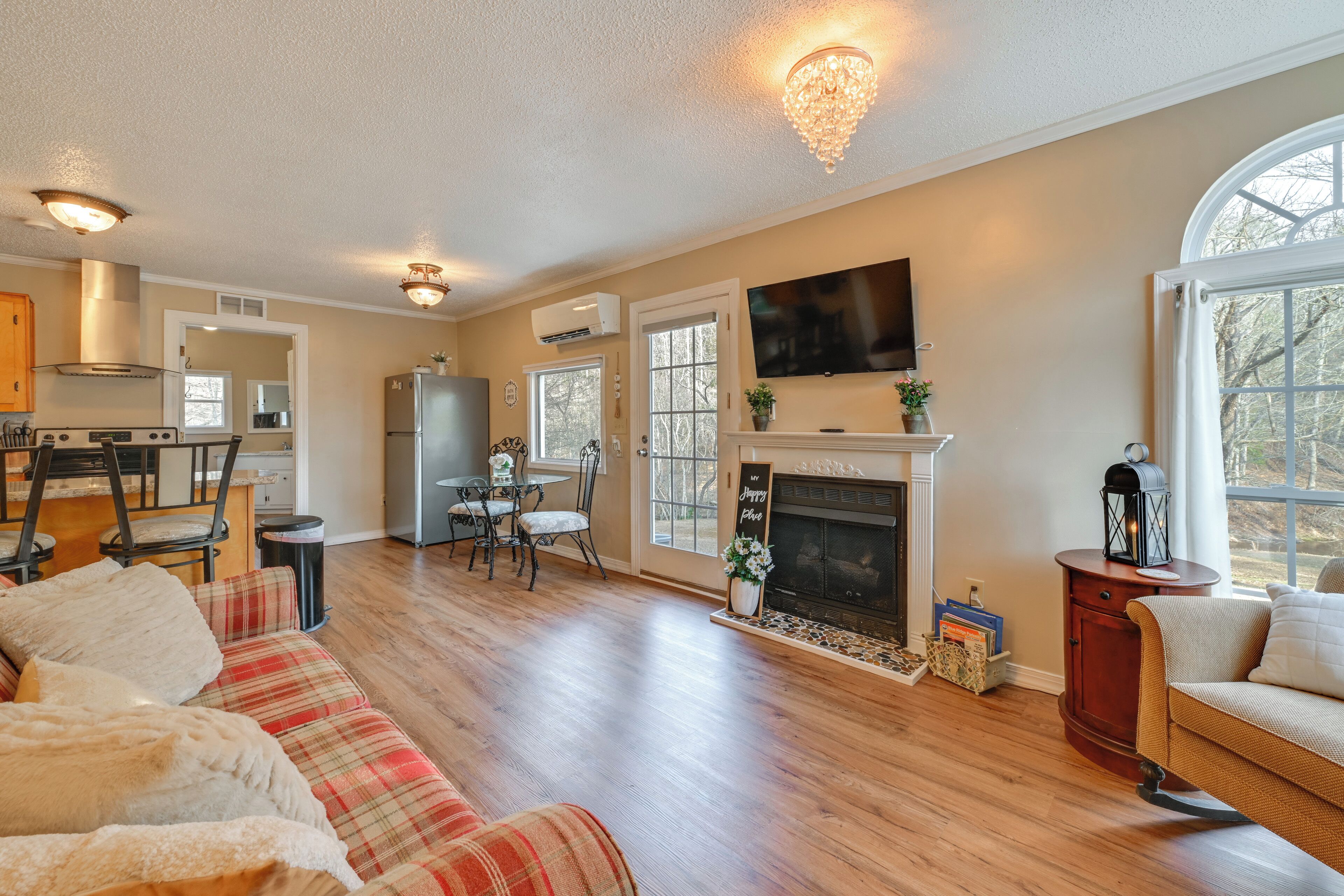 A spacious living room with a fireplace, a dining area, and a kitchen.