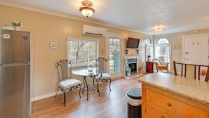 A kitchen with a stainless steel refrigerator, a glass dining table with four chairs, and a wooden cabinet. - Hike, Swim & Fish On-site: Blue Ridge Mtn Getaway (Thurmond)