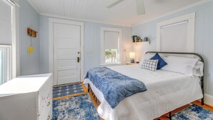 Une chambre à coucher avec un lit, un bureau et un ventilateur de plafond.