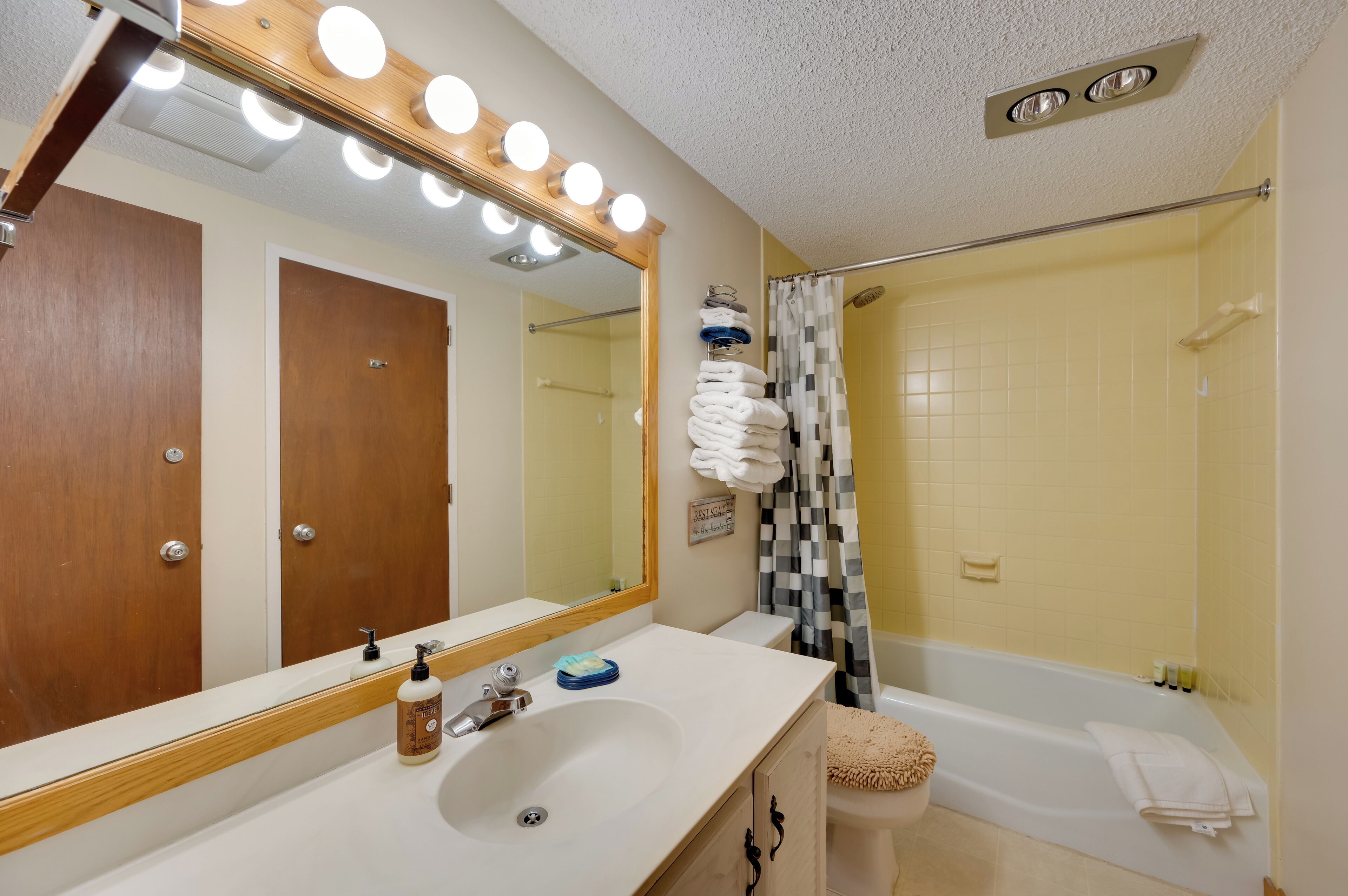 Un baño con lavamanos, espejo y ducha.