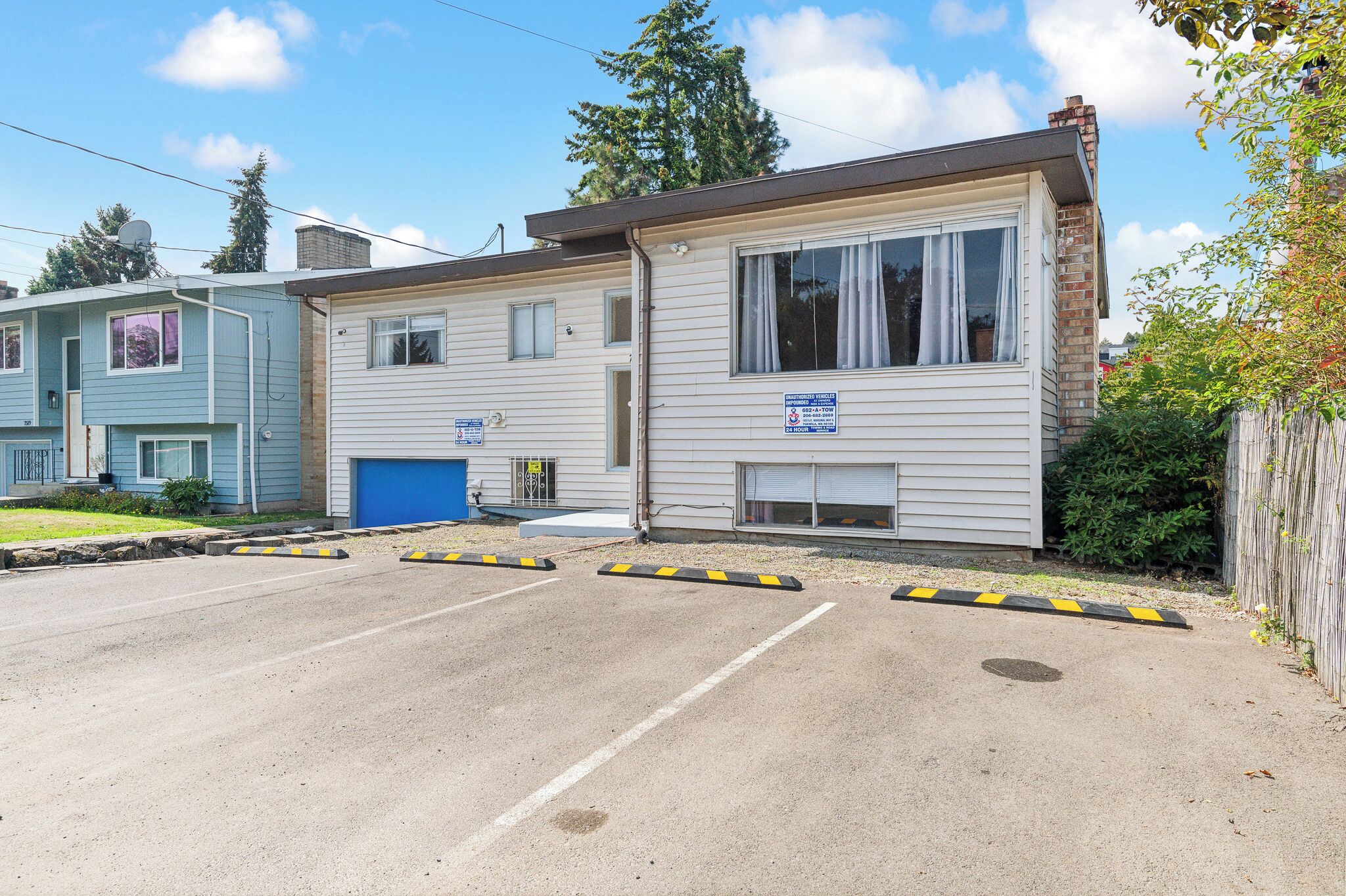 A two-story building with a garage and a parking lot.