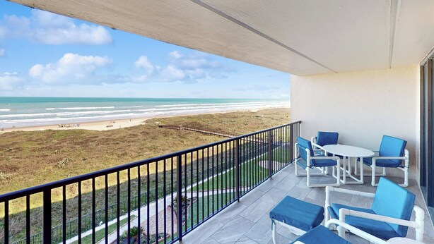 A balcony with a view of the beach, outdoor furniture, and a railing. - Gulf-front 2BR w/ Balcony: Suntide III - Unit 502 (South Padre Island)