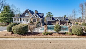 A two-story house with a covered porch, a swimming pool, and a fenced yard. - Near Atl! Spacious Townhome w/ Patio & WFH Setup (Douglasville)
