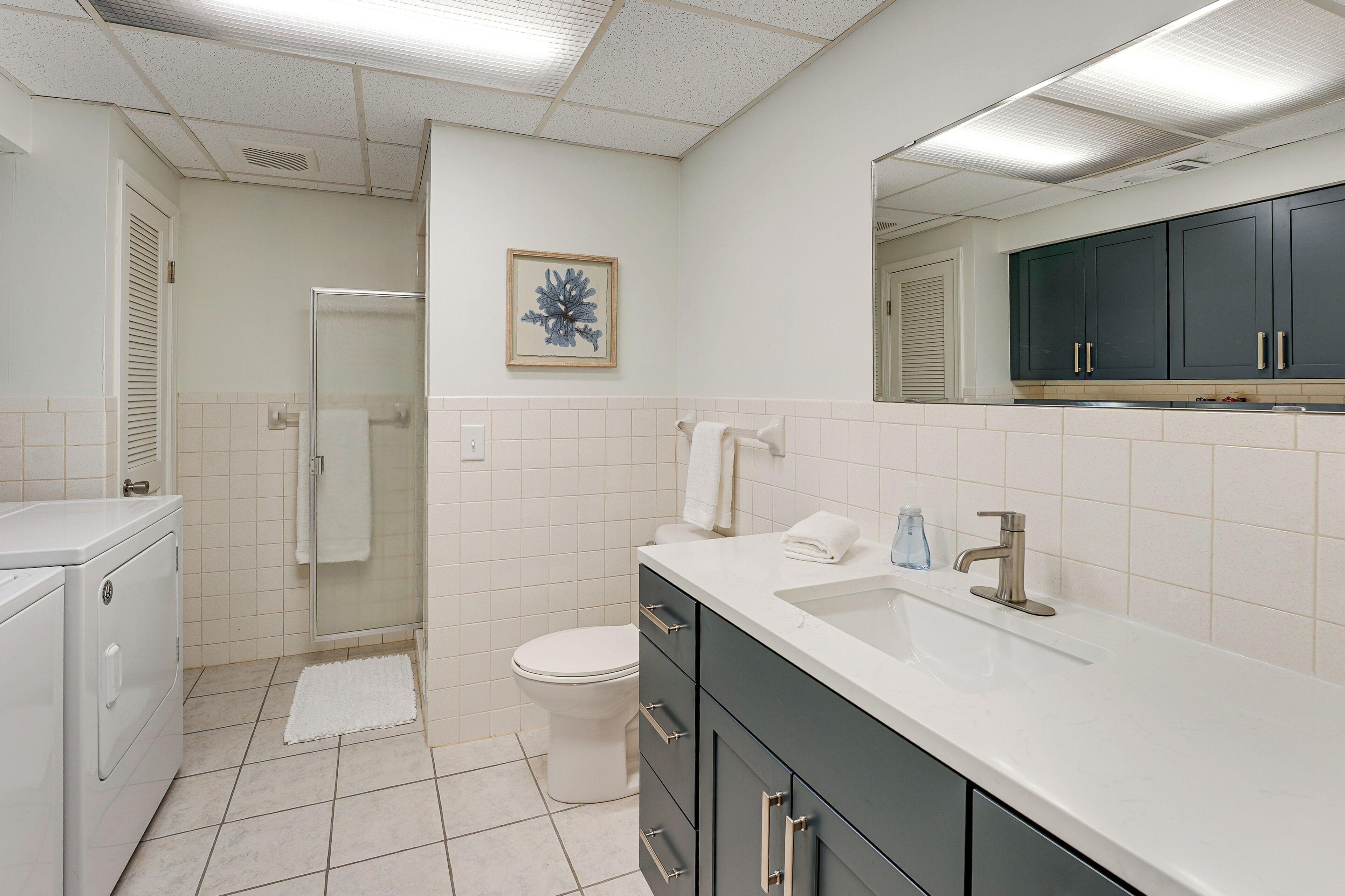Un baño moderno con cabina de ducha, inodoro y lavabo con espejo.