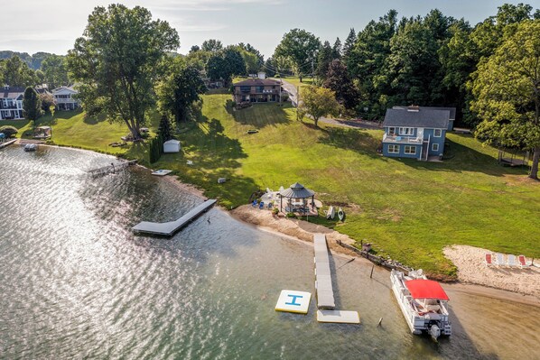 An aerial view of a lakeside property with a dock, a gazebo, and a boat. - Private Beach, 3,000 Sq Ft: Murray Lake Retreat! (Lowell)