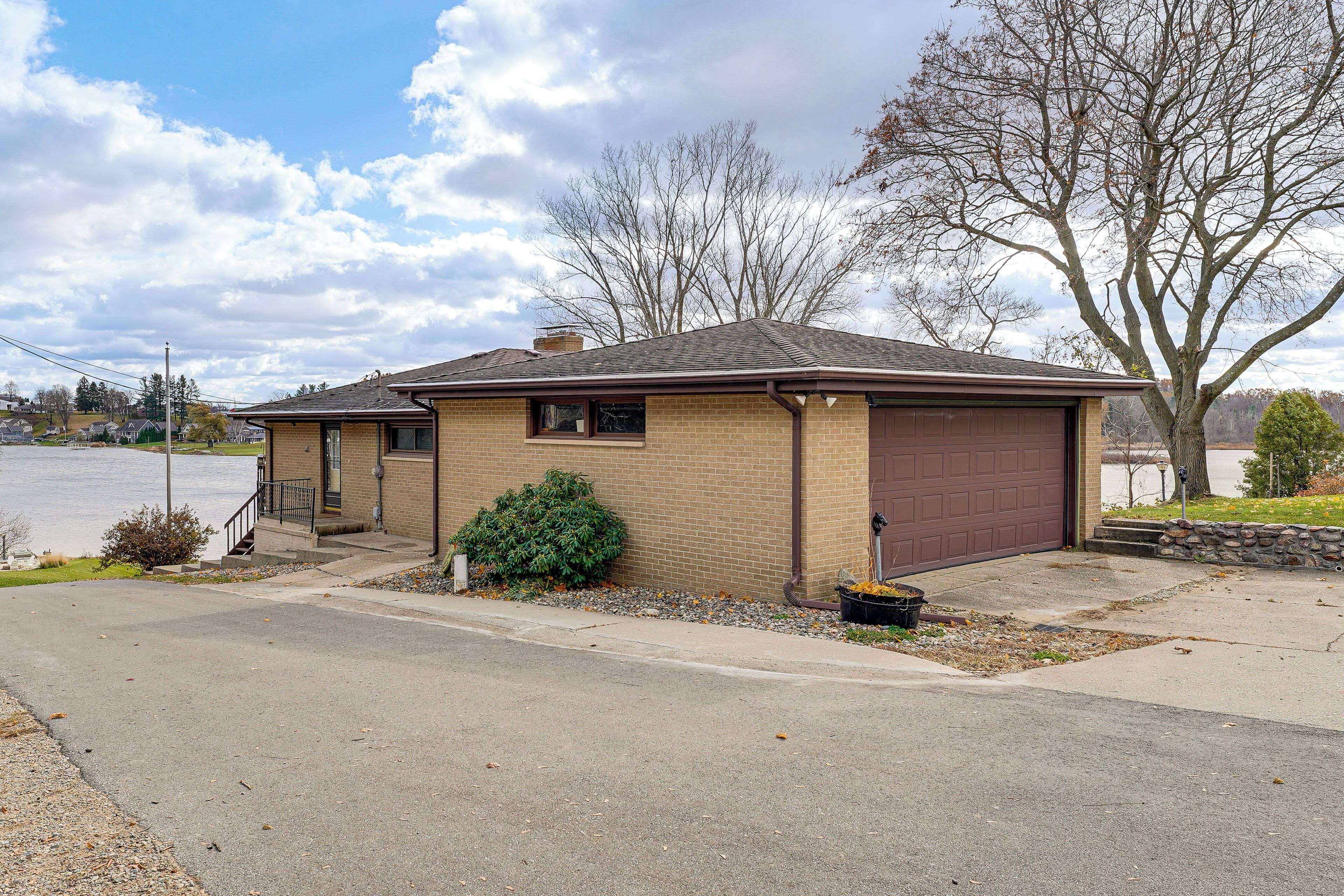 A single-story house with a brown garage, a small front porch, and a well-maintained lawn.