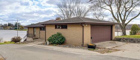 A single-story house with a brown garage, a small front porch, and a well-maintained lawn.
