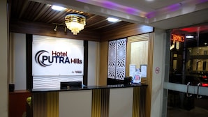 A reception desk at Hotel PUTRAHILLS with a modern design, including a chandelier and a sign displaying the hotel's name. - Hotel Putra Hills at WTCKL (Kuala Lumpur)