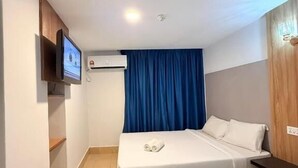 A hotel room with a bed, a TV mounted on the wall, an air conditioning unit, and a wooden panel on the wall. - Hotel Putra Hills at WTCKL (Kuala Lumpur)