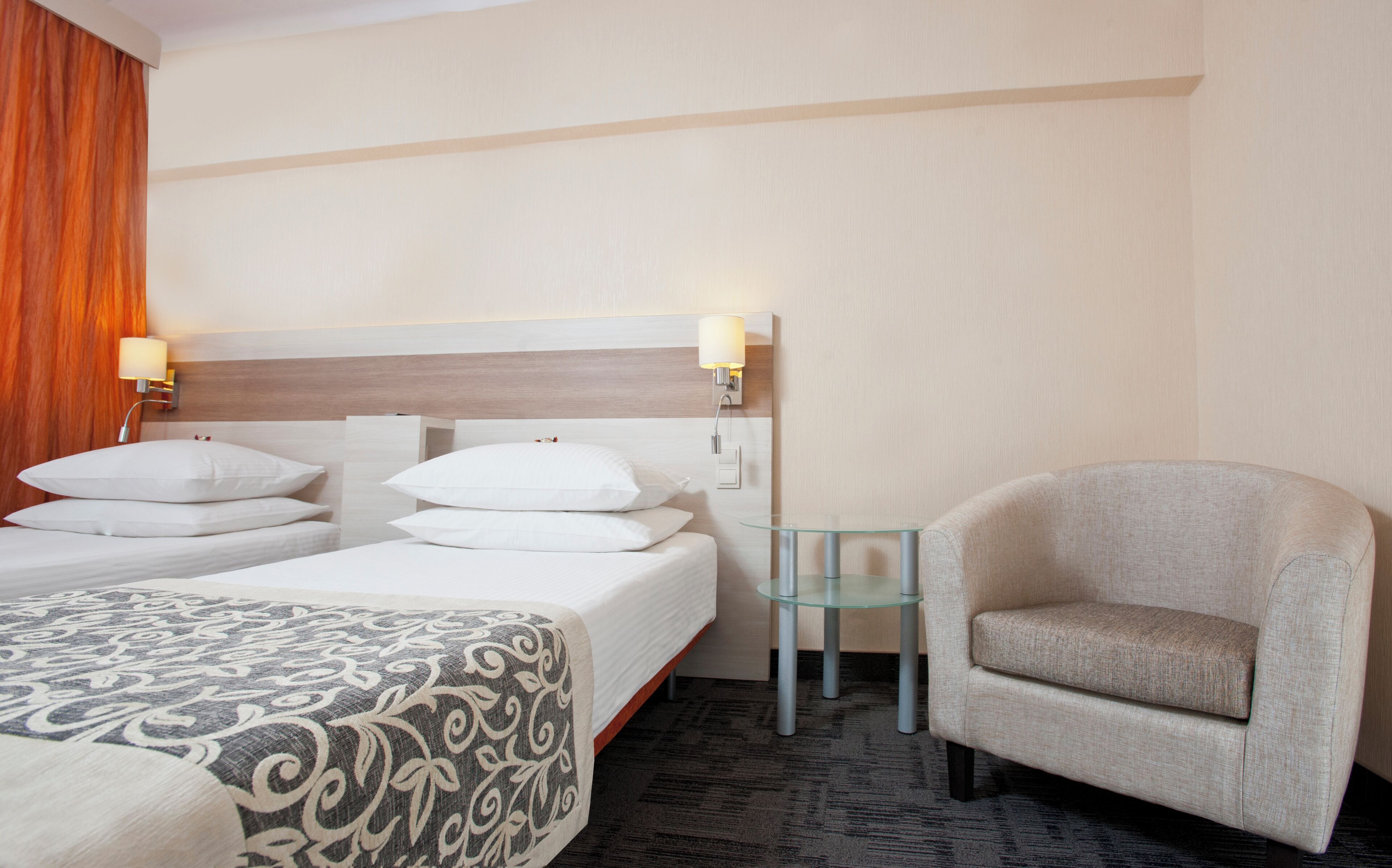 Une chambre d’hôtel avec deux lits, une petite table et une chaise.