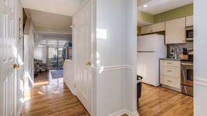 Eine moderne Küche mit weißen Schränken, einem Edelstahlkühlschrank und Holzboden.