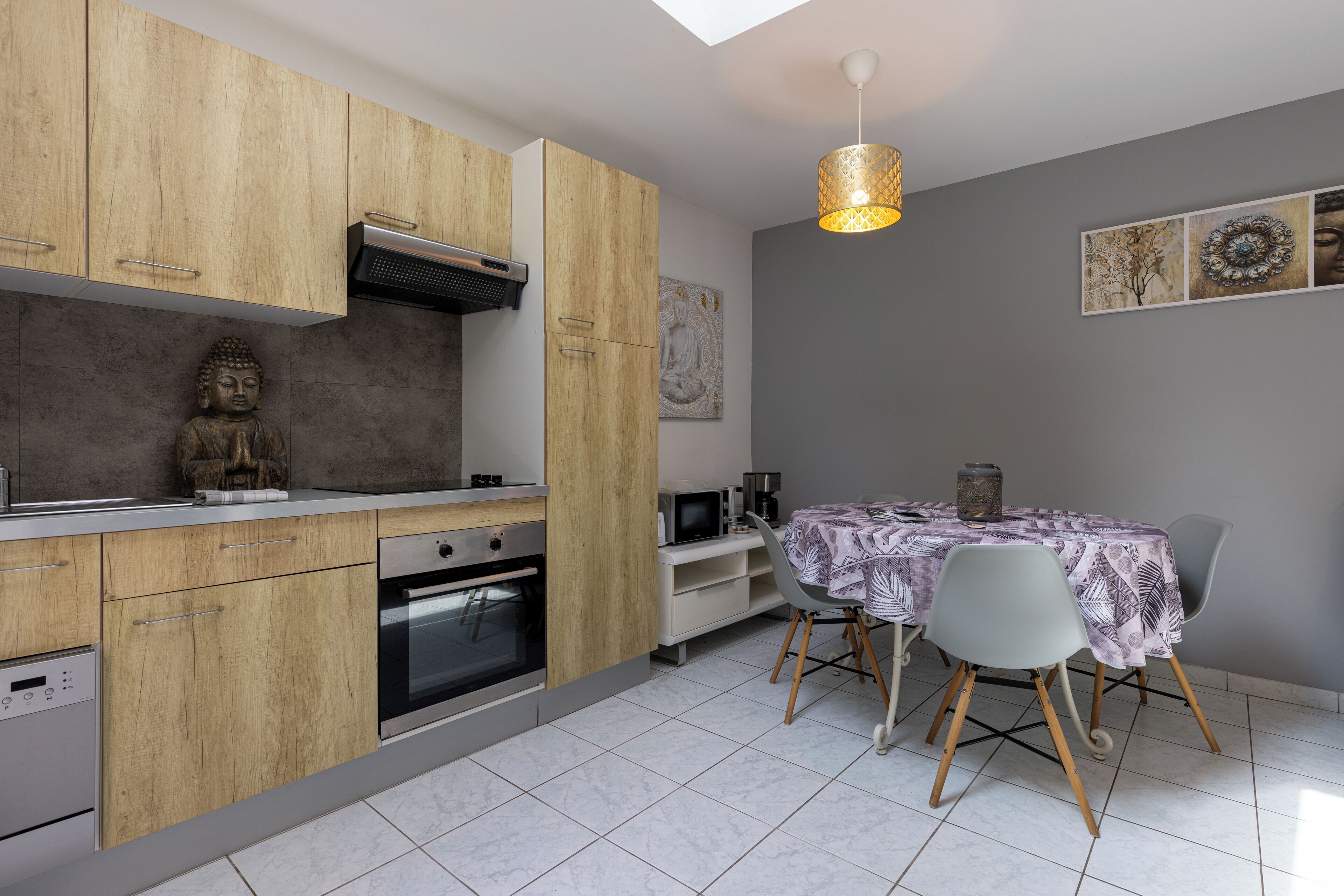 Eine moderne Küche mit Holzausbau, einem eingebauten Backofen und einem Essbereich mit Tisch und Stühlen.