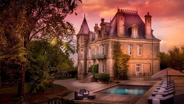 A large, historic stone building with multiple towers and a swimming pool. - Le Château des Tourelles en Vendée (La Gaubretière)