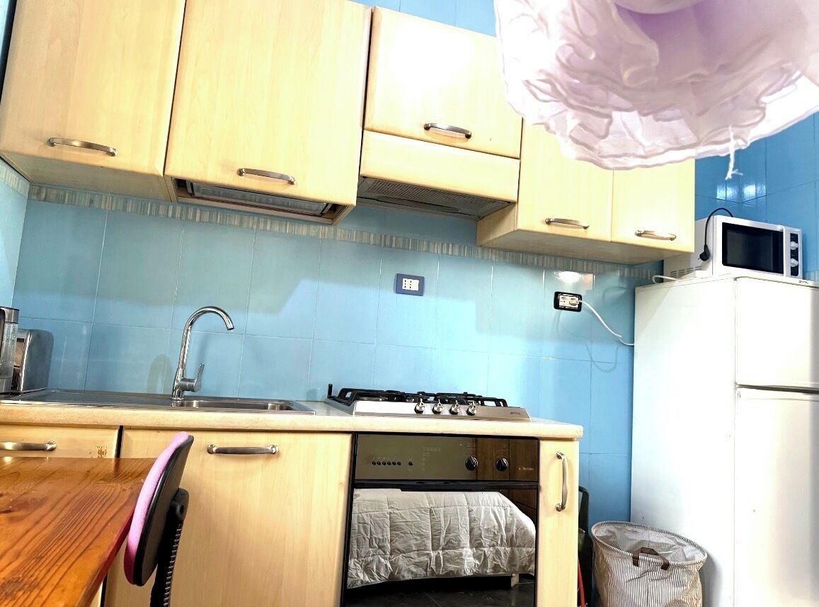 A compact kitchen with a gas stove, microwave, and refrigerator.