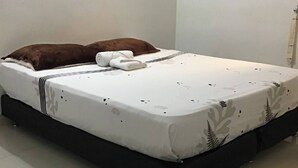 A bed with a white mattress and a brown pillow, a black bed frame, and a white wall. - Studio Apartament 1st Floor Piedrapintada Coffee Wifi TV (Ibagué)