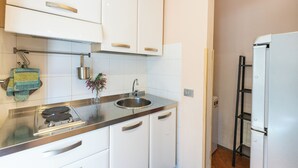 A modern kitchen with white cabinets, stainless steel appliances, and a black ladder. - Strozzi Apartment with view (Firenze)