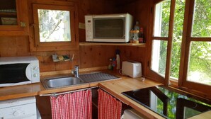 A compact kitchen with a microwave, toaster, sink, and a small refrigerator.