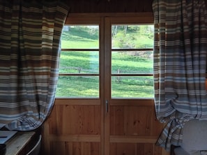 Una puerta de madera con vistas a un paisaje verde a través de una ventana.
