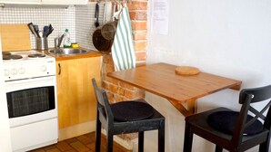 A kitchen with a brick wall, wooden cabinets, a stove, and two chairs. - Spacious apartment5 min from the center (Stockholms)