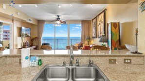 A kitchen with a large window, a ceiling fan, and a view of the ocean. - Come visit Sophomore! 2BR 2BA Beachfront Condo! Sleeps 6! (Panama City)