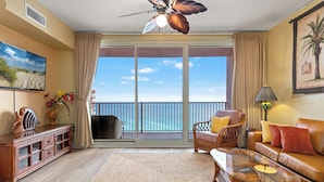 A living room with a large sliding glass door leading to a balcony with a view of the ocean. - Come visit Sophomore! 2BR 2BA Beachfront Condo! Sleeps 6! (Panama City)