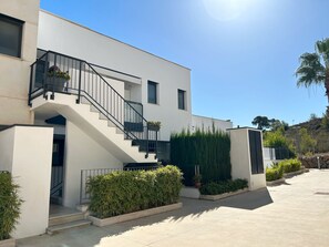 A modern two-story building with a staircase, a balcony, and a well-maintained garden area. - Beautiful modern flat with pool in Orihuela Costa (VC)