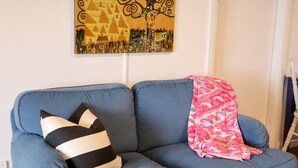 A blue sofa with a black and white striped pillow and a pink patterned throw blanket. - Towncottage Tenterfield Stay With Scenic Views (Tenterfield)