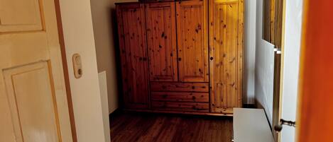 A room with wooden cabinets, a white door, and a wooden floor.