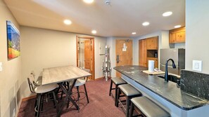 Una cocina compacta con comedor, refrigerador y pileta.