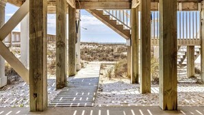 Eine Holzkonstruktion mit einer Treppe, die zu einem Sandstrand führt.