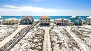 Ein Anwesen direkt am Strand mit einem zentralen Gebäude, einer unbefestigten Straße und mehreren kleineren Gebäuden.