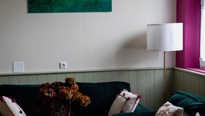 A room with a green sofa, a white lamp, and a painting on the wall. - The Little Cottage in the Bay of Somme (Cahon-Gouy)