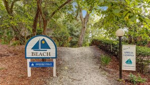 A sign for 'Beach' with a 'Owner Bike Storage' sign below it, and a welcome sign for 'Amelia Landings Condominium Resort Community'. - 4f Amelia Landings 2 Bedroom Condo (Fernandina Beach)