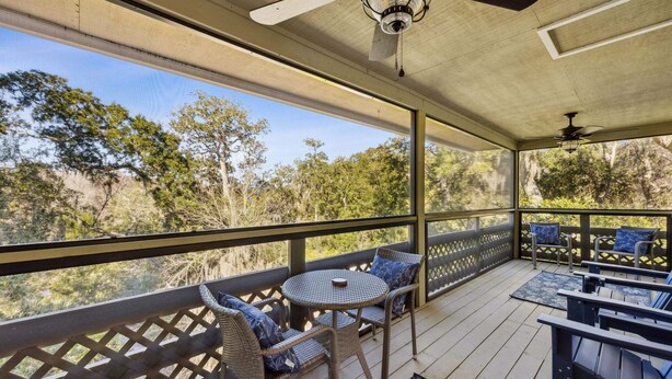 A covered outdoor area with wicker furniture, a round table, and a ceiling fan. - 4f Amelia Landings 2 Bedroom Condo (Fernandina Beach)