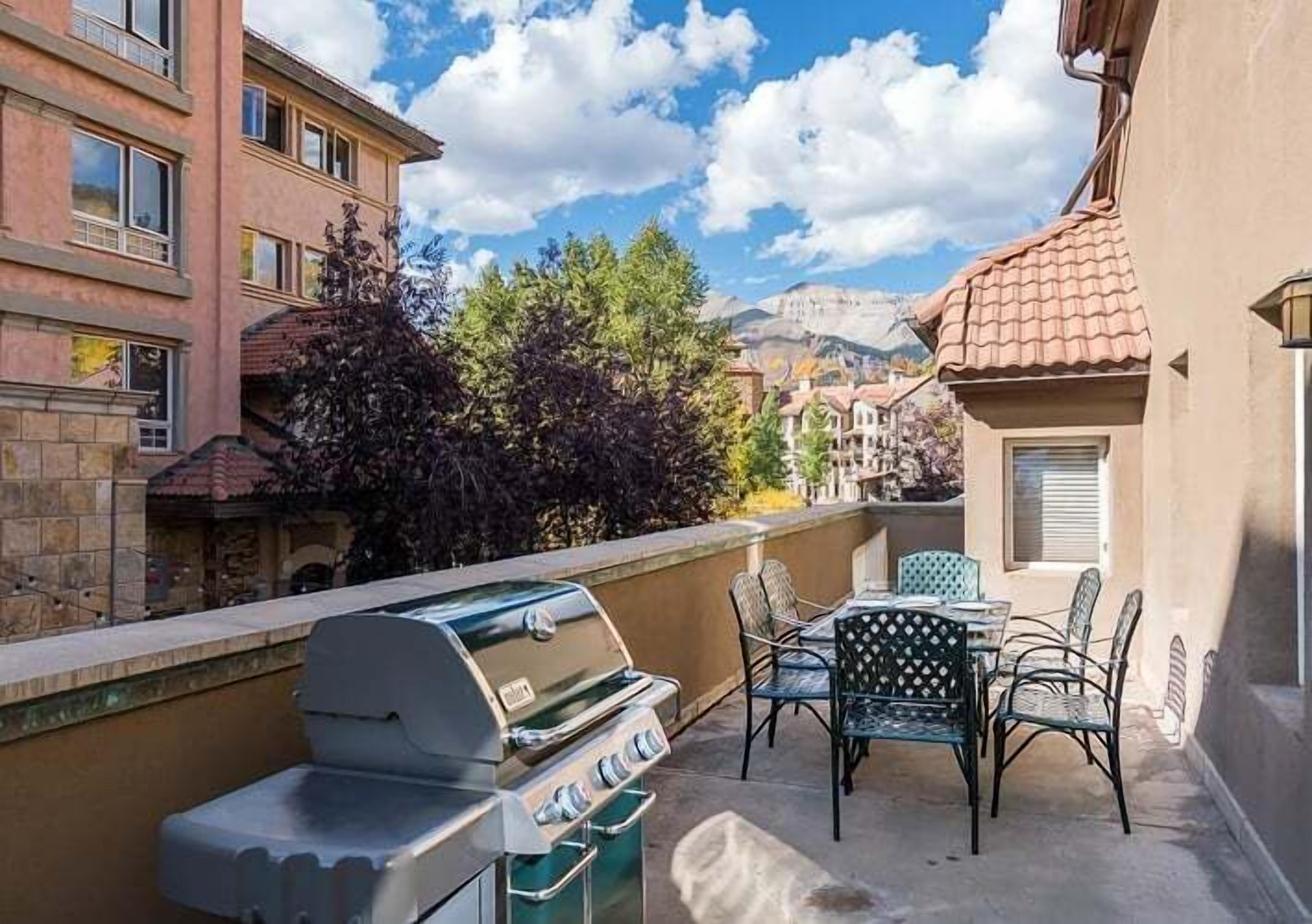 Un balcone con una griglia e posti a sedere all'aperto.