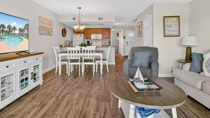 A spacious living area with a dining table, a sofa, and a TV. - Kontiki Bayfront K304 3 Bedroom Condo (Rockport)