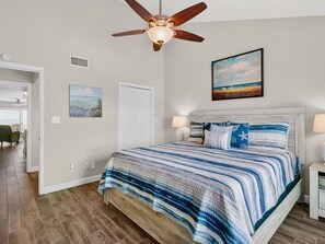 A bedroom with a bed, ceiling fan, artwork, and a view of the outdoors. - Kontiki Bayfront K304 3 Bedroom Condo (Rockport)