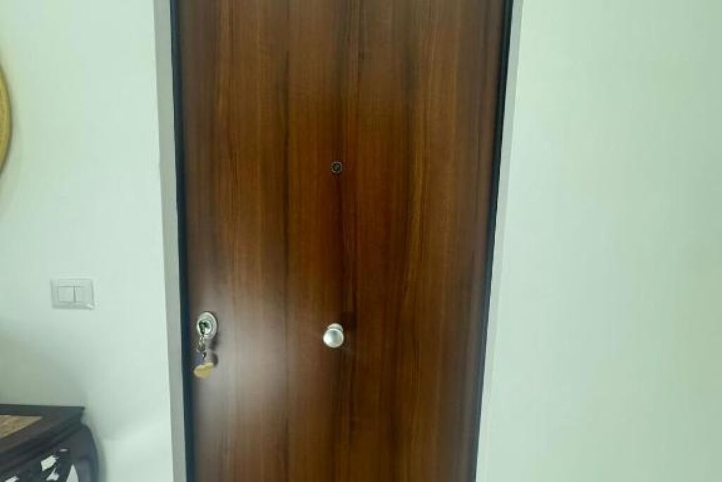 A closed wooden door with a keyhole and a round doorknob.