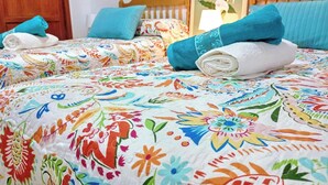 Een hotelkamer met twee bedden, beddengoed met bloemenprint en een houten hoofdbord.