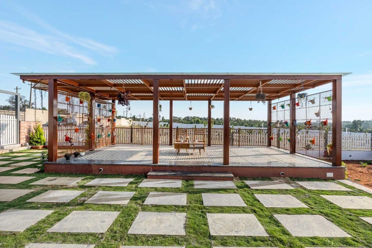 Un espacio al aire libre con techo y una pérgola, pavimento de piedra y vistas del paisaje circundante.