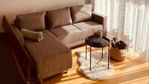 A modern living room with a sectional sofa, a small round table, and a fur rug. - House Annabelle Top 1 (Damüls)