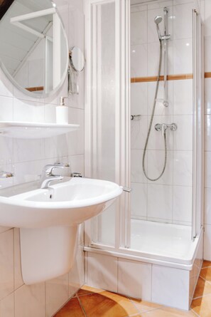 Regadera, secadora de cabello, toallas, papel de baño 