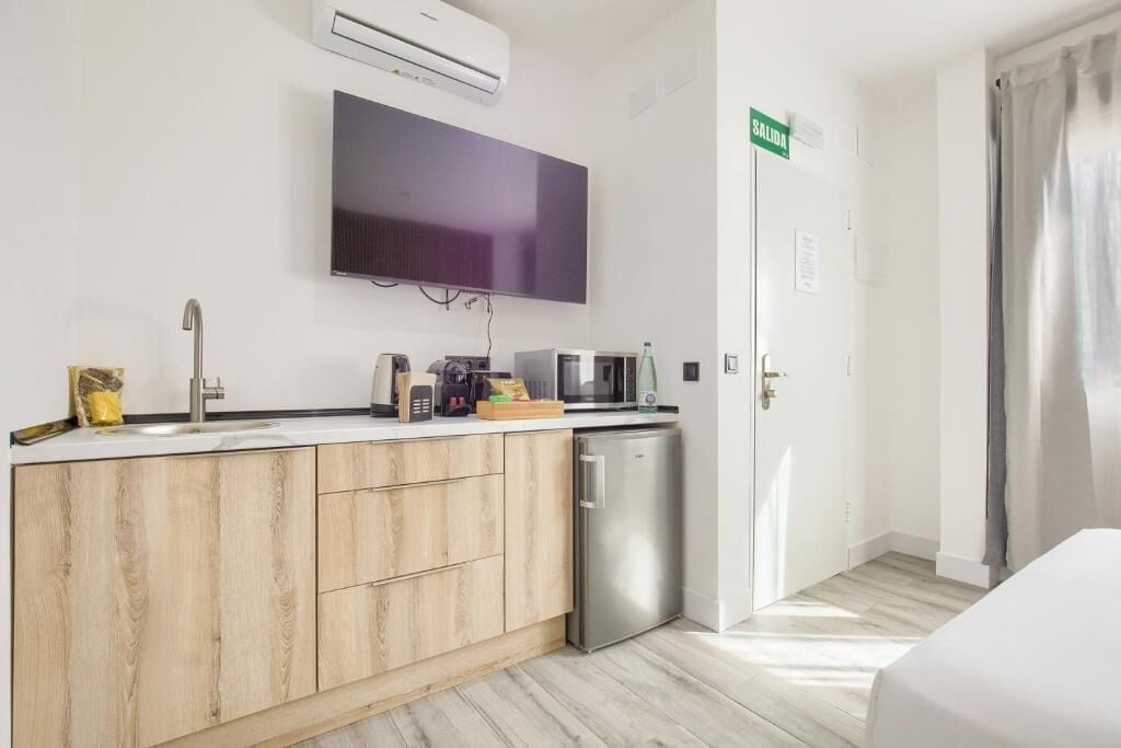 Una cocina moderna con microondas integrado, un lavabo y lavavajillas.