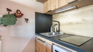 A kitchen with a sink, wooden cabinets, and a countertop. - Cute studio apartment for 4 people, balcony and garage (Chamrousse)